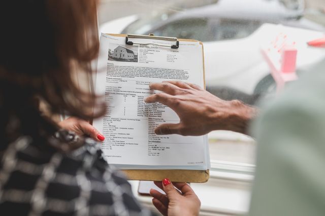 two people reviewing a rental property listing on a clipboard